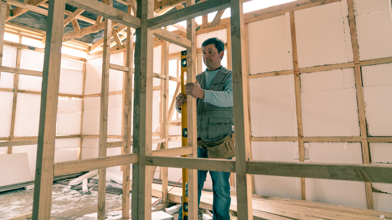 A Man Leveling a Wooden Structure